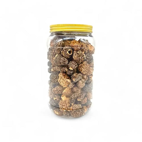 Dried morels Morchella Esculenta in a clear glass jar with yellow lid for gourmet cooking